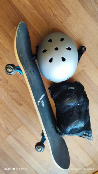 Monopatín con casco y protecciones