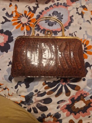 Bolso de mano marrón con detalles dorados
