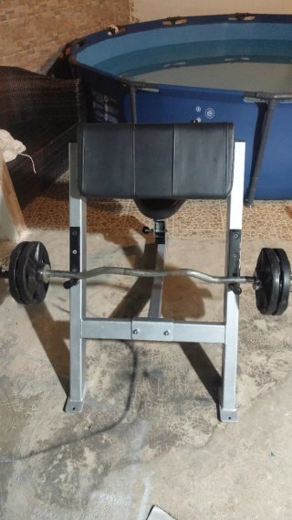 Banco de bíceps con barra y discos