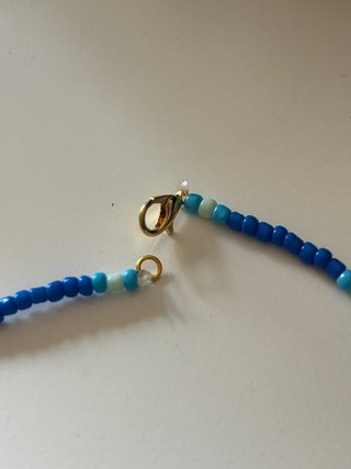 Collana perline blu con ciondolo dorato
