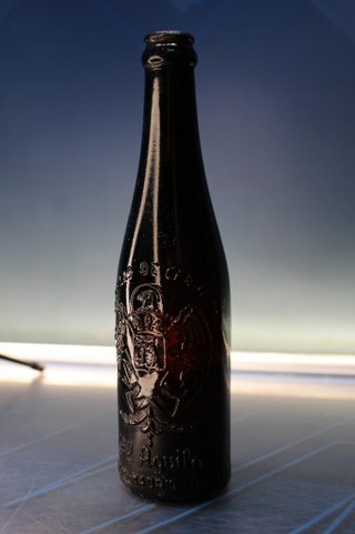 Botella antigua El Águila, ambar, con relieve.