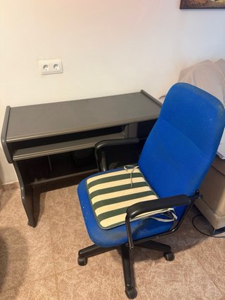 Escritorio gris con silla azul y altavoces