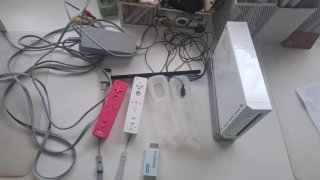 Nintendo Wii con un mando rosa y otro blanco