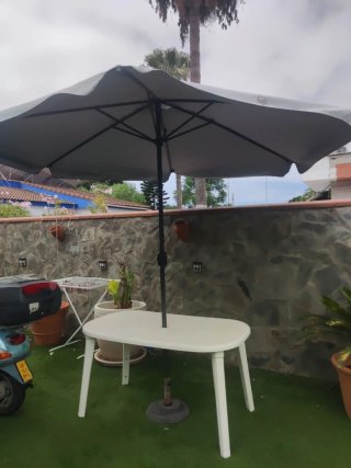 Mesa de patio blanca y sombrilla gris