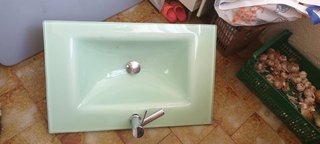 Lavabo de cristal verde con grifo