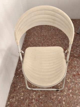 Silla plegable blanca de plástico y metal.
