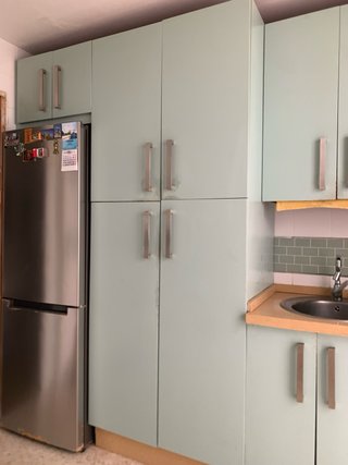 Cocina completa con muebles, encimera, campana y 2