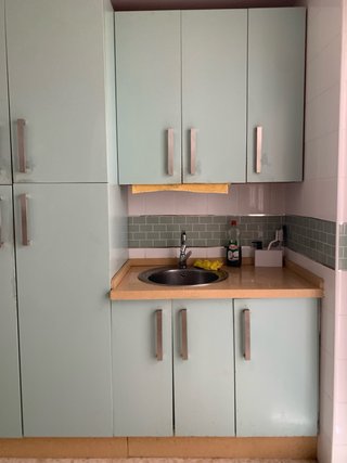 Cocina completa con muebles, encimera, campana y 2