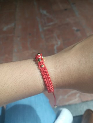 Pulsera roja con mariquita dorada