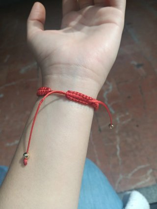 Pulsera roja con mariquita dorada