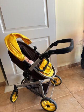 Carrito de bebé Miyo con accesorios y dos bebés.