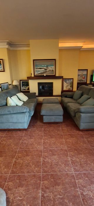 Sofá de tela verde con 2 reposapiés