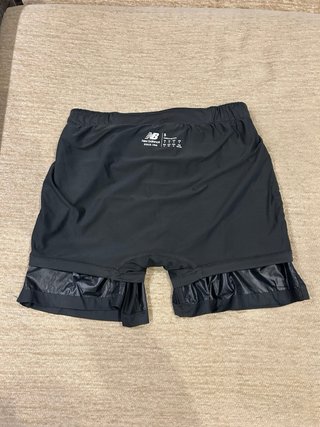 Pantalón corto running New Balance 2 en 1. T-S.