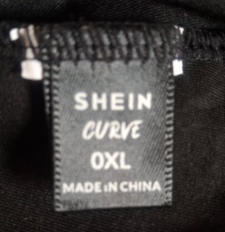 Camiseta sin mangas negra con letras rosas.