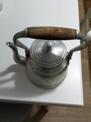 Tetera de metal con mango de madera