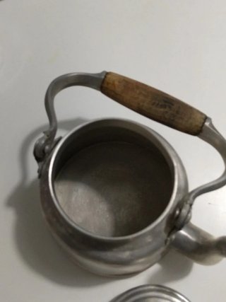 Tetera de metal con mango de madera