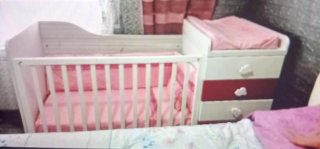 Cuna de bebé blanca y rosa con cambiador
