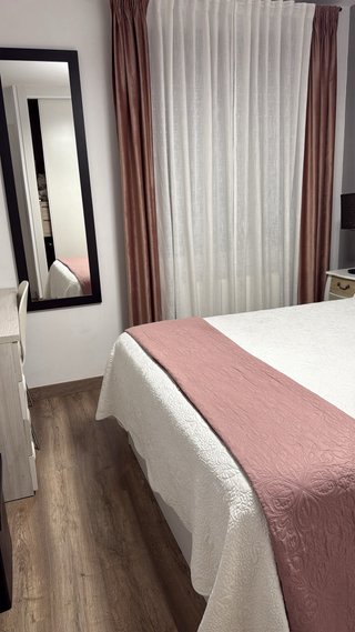 Cortinas y colcha rosa y blancas