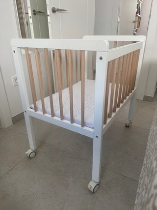 Minicuna de madera blanca con barrotes de madera