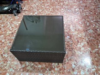 Mesa de jardín de cristal y mimbre