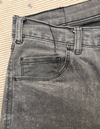 Pantalones grises desgastados con rotura