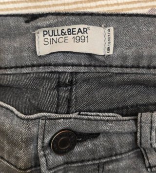 Pantalones grises desgastados con rotura