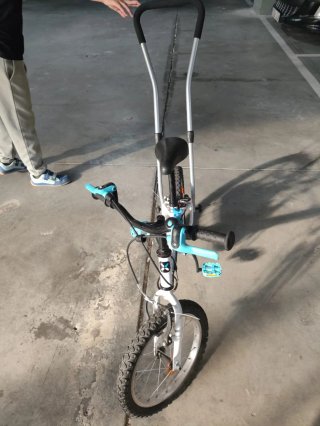 Bicicleta infantil con barra de aprendizaje.