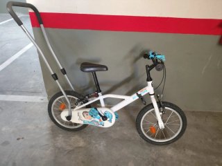 Bicicleta infantil con barra de aprendizaje.