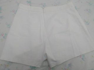 Falda pantalón corta blanca con botones negros.