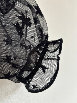 Top corto negro transparente con estrellas negras.