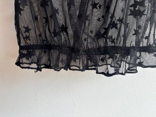 Top corto negro transparente con estrellas negras.