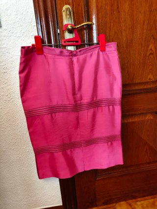 Traje de falda rosa con chaqueta y top.