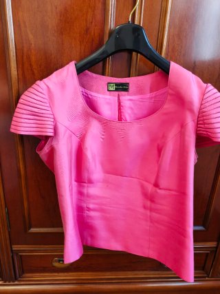 Traje de falda rosa con chaqueta y top.