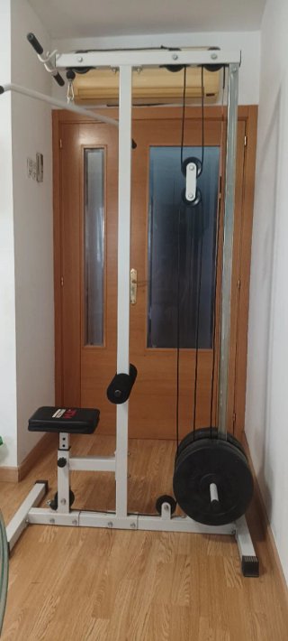 Varias máquinas de musculación junto con pesas y m