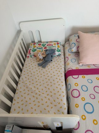 Cuna blanca con dosel y detalles infantiles