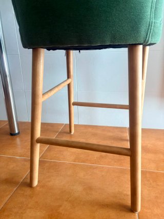 Silla verde de tela con patas de madera