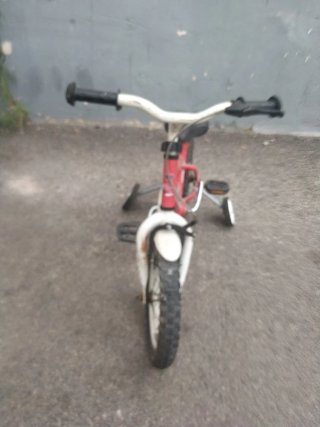 Bicicleta infantil roja con ruedines