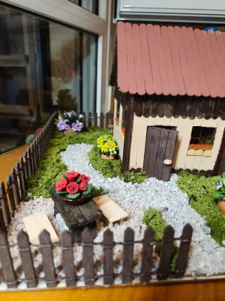 Jardín miniatura con casita madera.