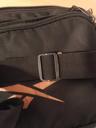 Bandolera Reebok Negra y Dorada.