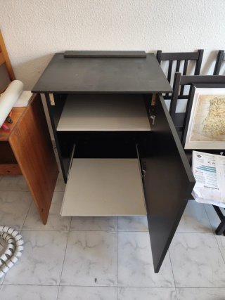 Mueble negro con ruedas con puerta.