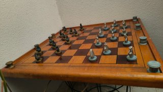 Scacchiera in legno con pezzi in bronzo e argento