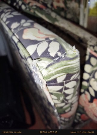 Sofá-cama floral con esquinas deterioradas