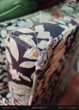 Sofá-cama floral con esquinas deterioradas