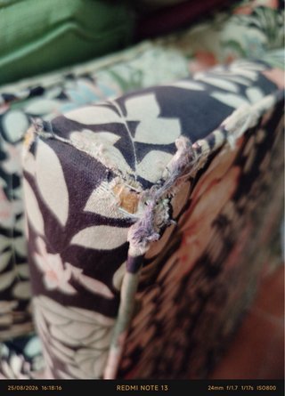 Sofá-cama floral con esquinas deterioradas