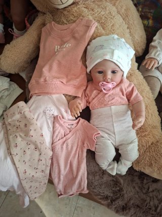 Muñeca realista con chupete y muchos complementos.