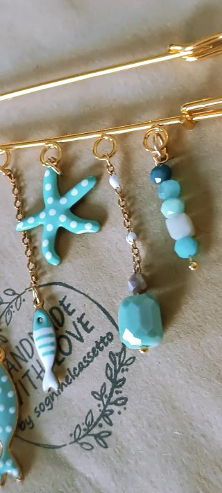 Spilla dorata con ciondoli a tema marino