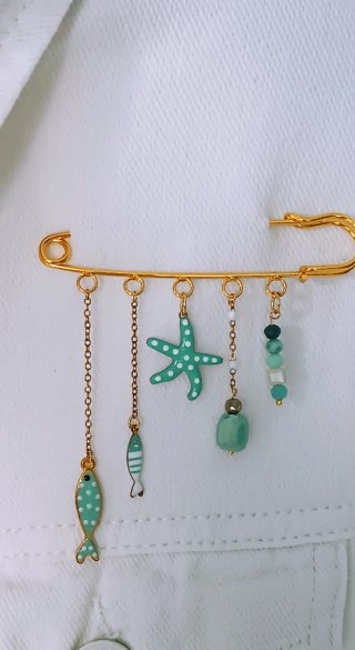 Spilla dorata con ciondoli a tema marino