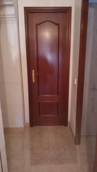 Puerta de madera con manilla dorada