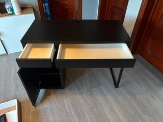 Escritorio IKEA oscuro con cajones y almacenaje.