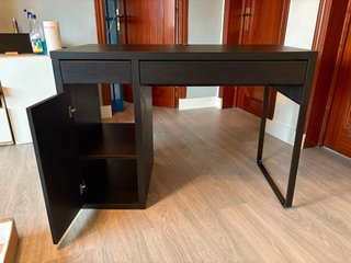 Escritorio IKEA oscuro con cajones y almacenaje.
